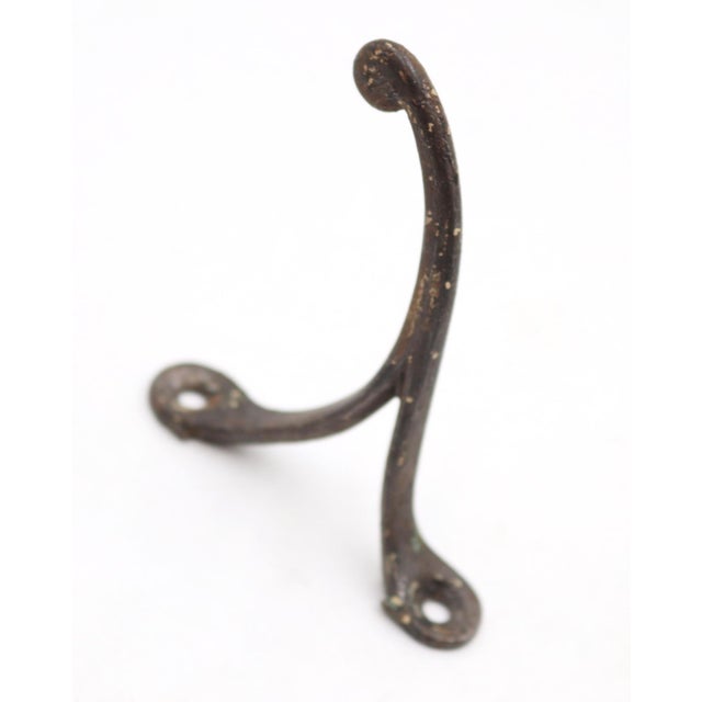 Vintage single arm black finished cast iron wall hook with a ball tip. The original mounting screws are not available....
