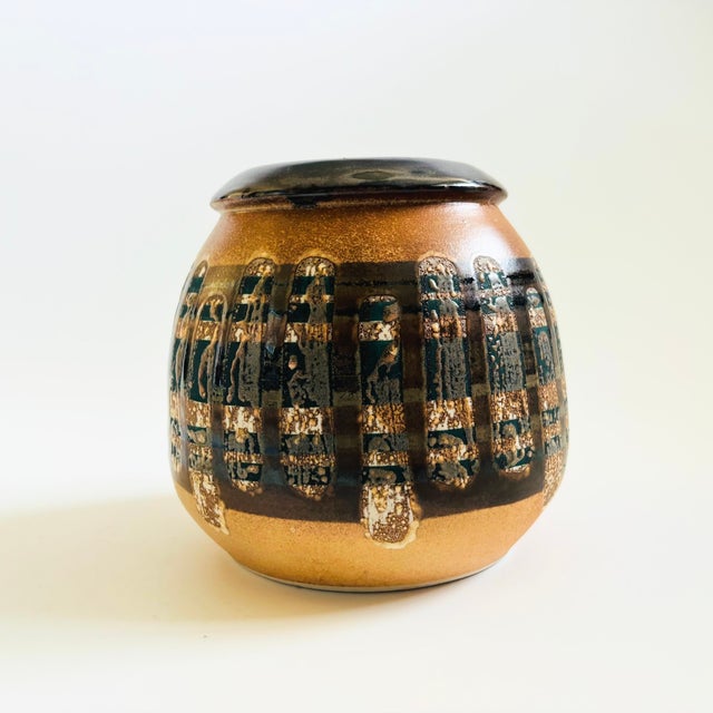A mid century pottery vase produced by Lapid Pottery of Israel. Finished in a layered fat lava glaze of earth tone colors...