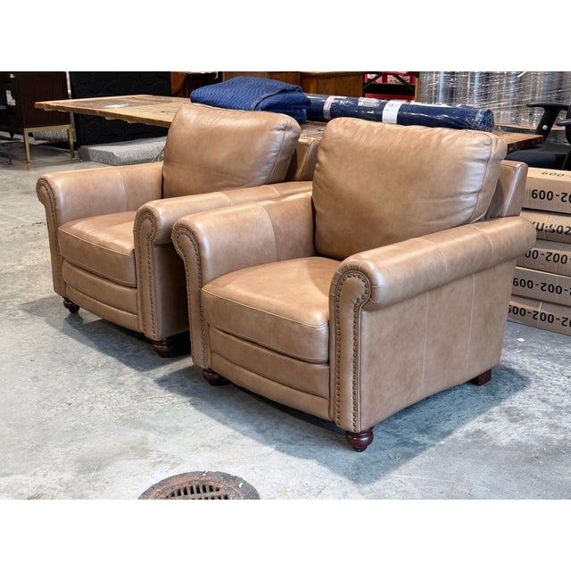 A handsome pair of Bassett Jackson leather chairs with a substantial, traditionally tailored presence. Upholstered in warm...
