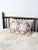 A vintage quilted pillow cover featuring a classic wedding ring pattern in soft floral pinks and blues against a warm...