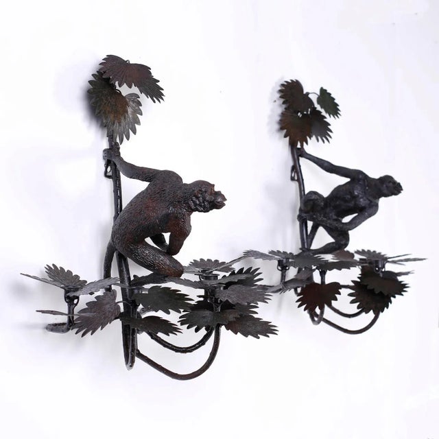 Pair of wall sconces with a slightly oxidized finish, five candle cups in palm leaf clusters, and featuring cast iron...