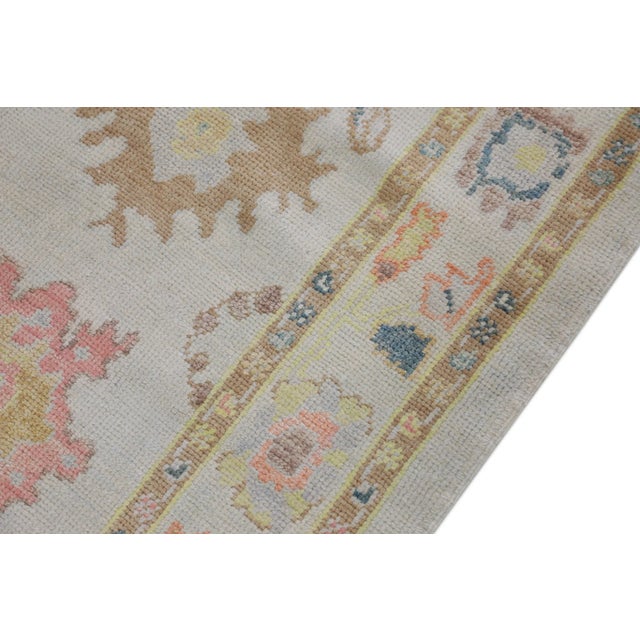 This modern Turkish Oushak rug is a stunning piece of art that has been handwoven using traditional techniques by skilled...