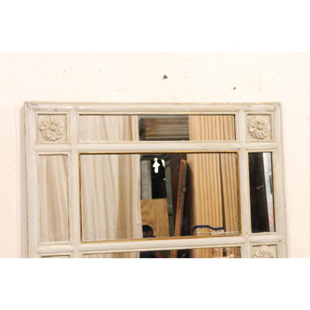 A large French painted wood mirror, with mirrored panel surround, from the 19th century. This antique wall mirror from...