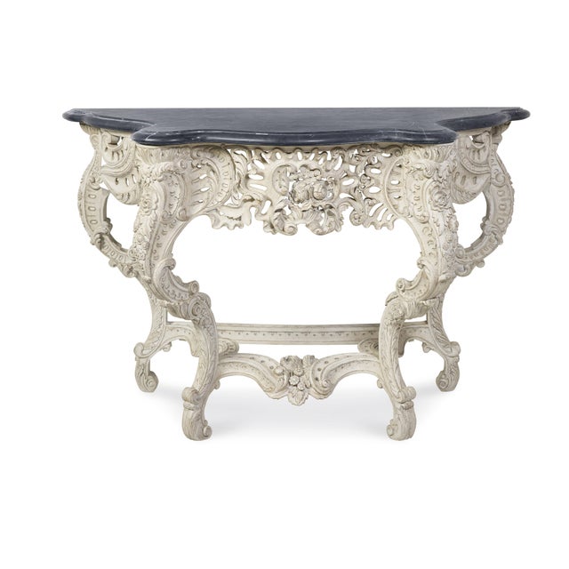 Inspired by an 18th Century Louis XV elaborately carved console with a black honed marble top exemplifies the Rococo...