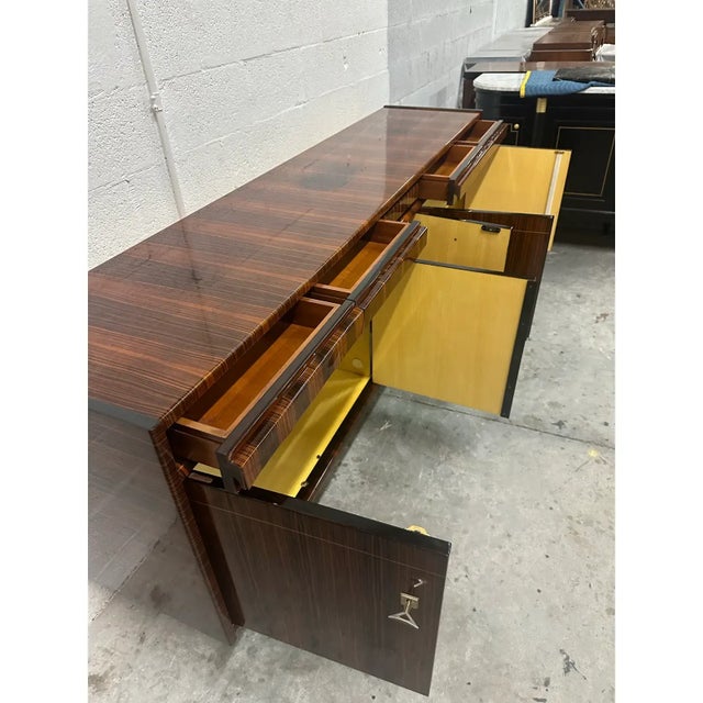 Classic French art deco exotic Macassar ebony sideboard. The buffet has four drawers over five doors, center bar section,...