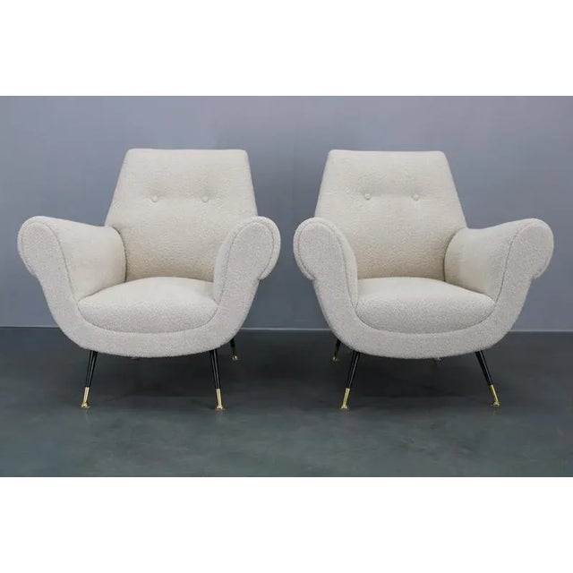 Pair of restored Italian armchairs from the 1950s featuring newly upholstered boucle fabric, elegant curved arms, and...