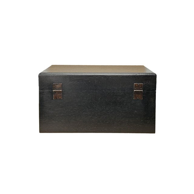 This elegant, rectangular wooden accent chest features a deep, dark brown-black finish that highlights the subtle, natural...