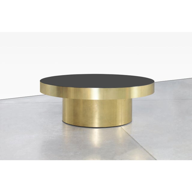 Beautiful vintage round brass and smoked glass coffee, designed in the United States, circa 1980s. This piece is crafted...