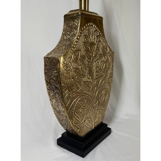 Vintage repousse brass floral and leaf patterned urn form table lamp. Patterning on all sides of lamp. Textural black band...