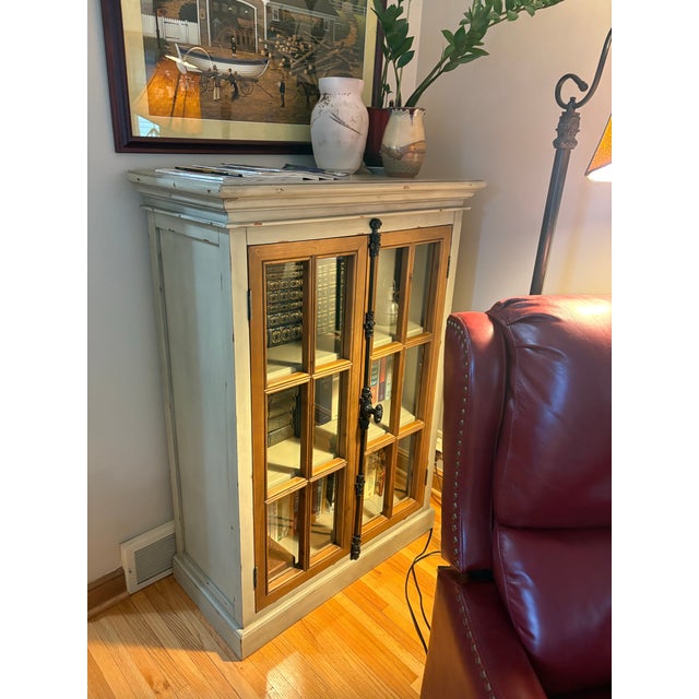 A very cool bookcase with 3 adjustable shelves and doors that have a unique latching mechanism. Distressed paint for a...