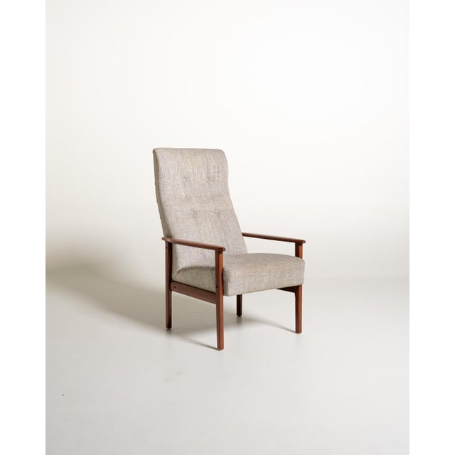 Armchair with teak frame, padded seat, and a high, slightly inclined backrest with capitonné workmanship. Scandinavian...