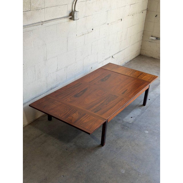 Danish Mid-Century Modern coffee table crafted in richly grained rosewood. This versatile drop-leaf design features two...