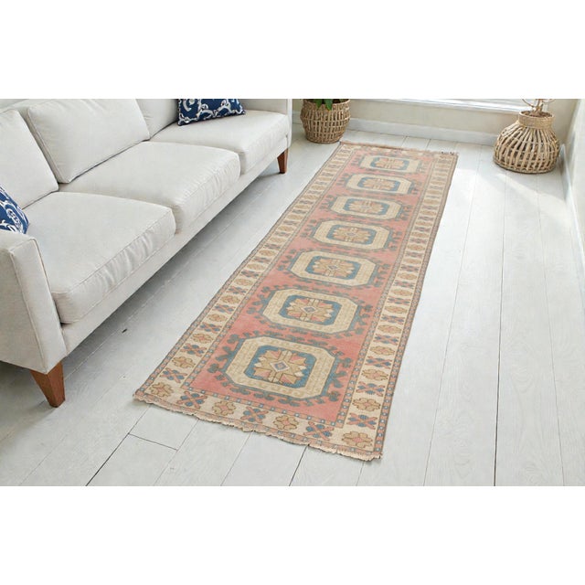 This is a vintage Turkish Oushak rug from the Mid 20th Century. The piece was hand-knotted.