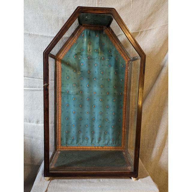 Mahogany and glass reliquary case with marble feet, from a convent in central Wisconsin; original wallpaper and paper...
