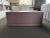 Brand new custom ottoman in a deep mauve leather, with hidden wheels, custom-built by a high end workroom in New Jersey....