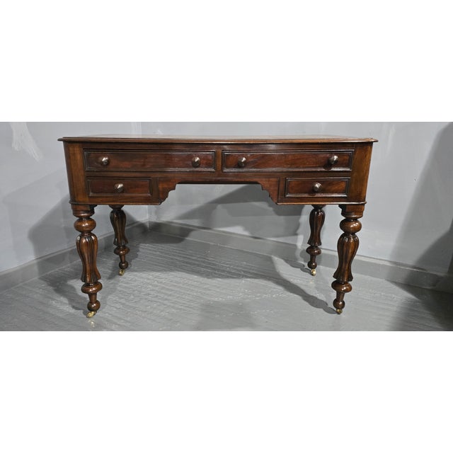 A very good William 4th style Victorian mahogany four drawer writing table, with brass castors amd beige leather top,...