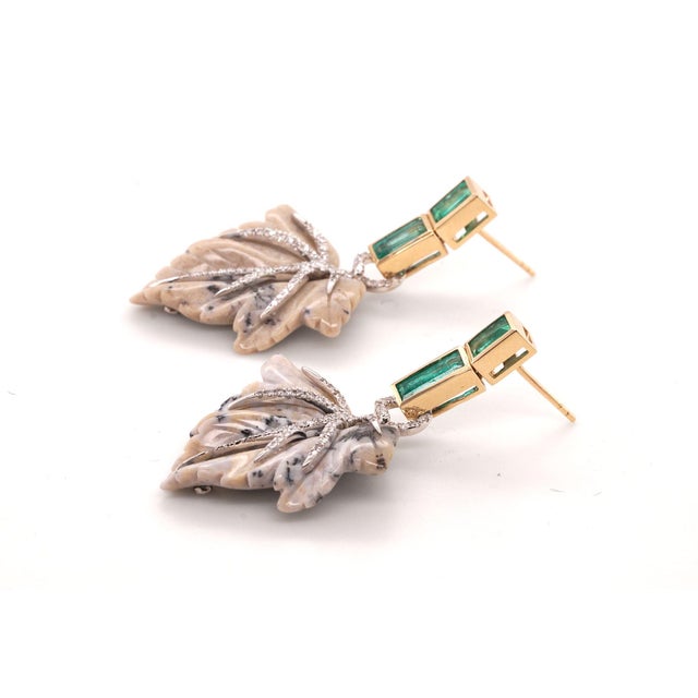 Statement earrings in 14ct yellow gold with emeralds, carved jasper leaves, and diamond accents. A sculptural blend of...