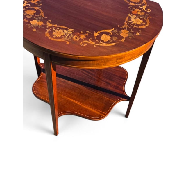 This 19th Century English Sheraton Mahogany Marquetry Center Table is a classic and elegant piece of antique furniture....