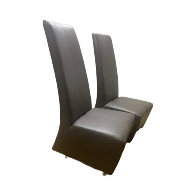 This pair of Elika dining chairs by Brueton features a tall, slender, and sleek profile upholstered in chocolate leather....