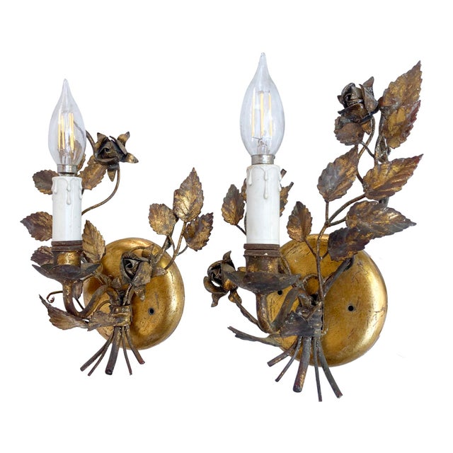 This pair of Vintage Italian Hollywood Regency-style wall sconces features a Florentine gilt gold tole design with metal...