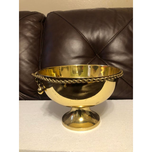 Add a touch of warm, reflective glam to your tabletop with this vintage Hollywood Regency polished brass pedestal bowl....
