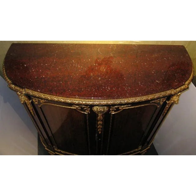 This Louis XVI style meuble a hauteur d' appui has a warm, reddish brown patina, and is crafted from mahogany with...