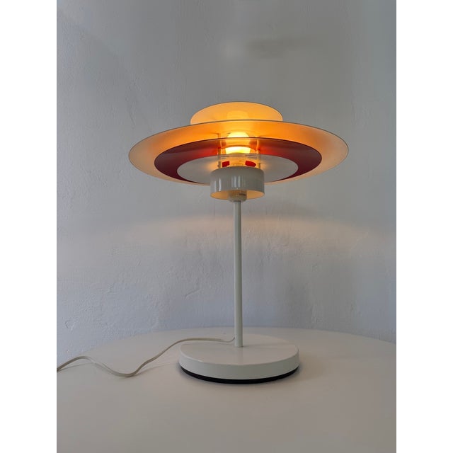 Classic Danish table lamp inspired by the designs of Poul Henningsen. The characteristic multi-layered shade with a red...