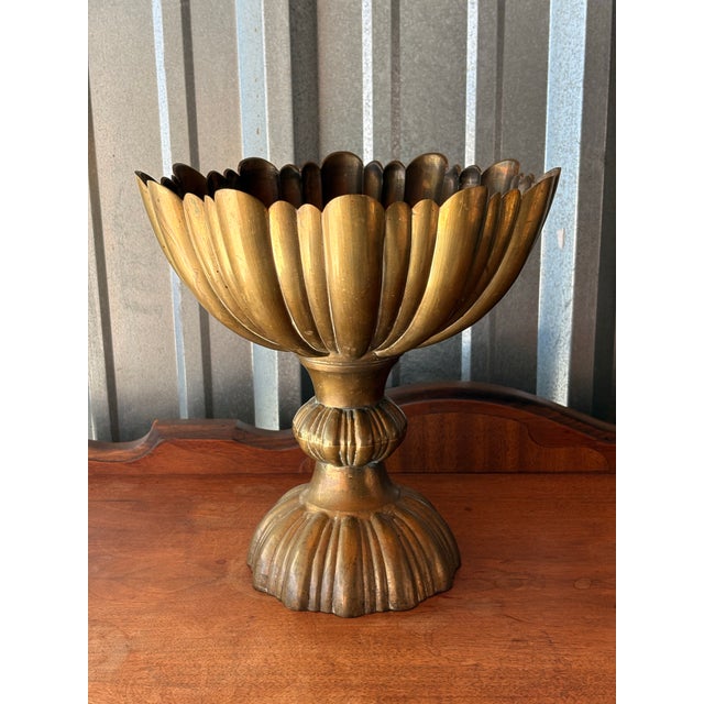 Hollywood Regency-style vintage scalloped and fluted brass pedestal compote bowl. It is commonly used as a tabletop floral...