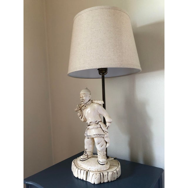Cream colored pair male and female asian figural lamps with sand-colored linen shades. Excellent condition with two prong...