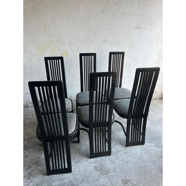 Introduction This set of six vintage dining chairs features a black painted wooden frame with upholstered seats. The tall,...