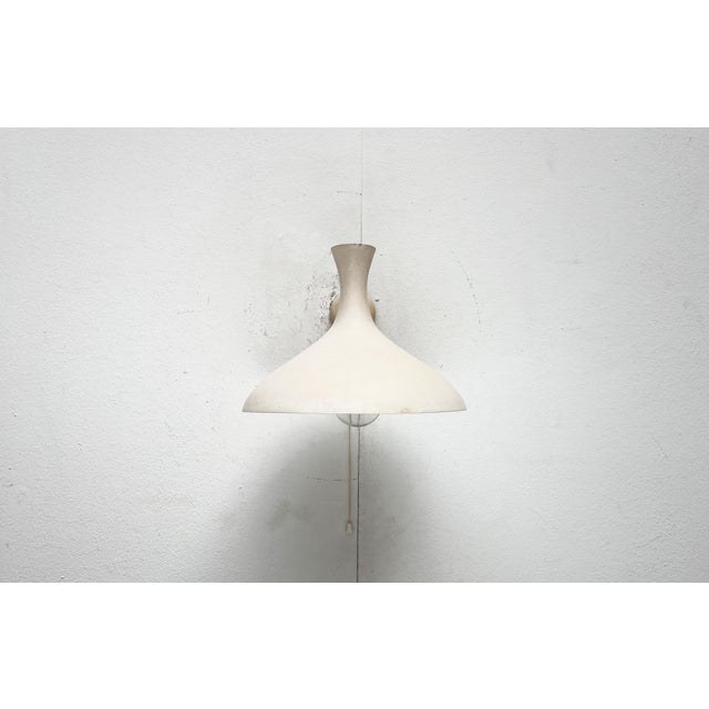 Mid-century wall lamp by Cosack with a striking Diabolo shade. Better known in the table lamp version with a “crow’s...