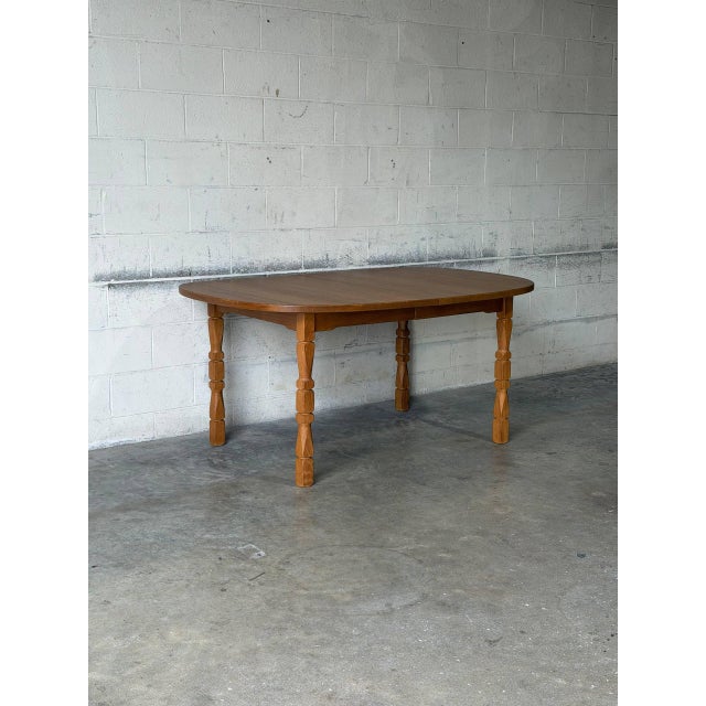 This fixed oval dining table features a broad top and a robust base. The silhouette is elevated by beautifully detailed...