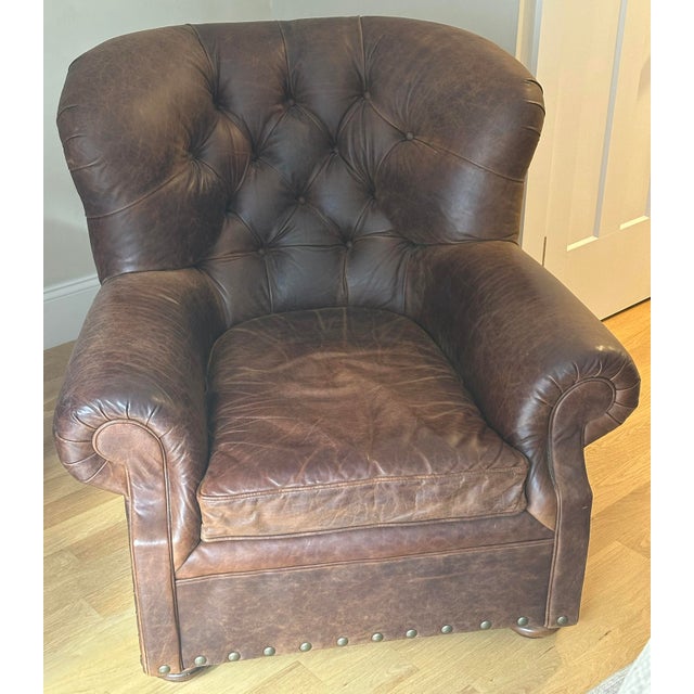 This is a vintage Restoration Hardware Leather Buster Chair, featuring an amply padded frame, button-tufted back, pleated...