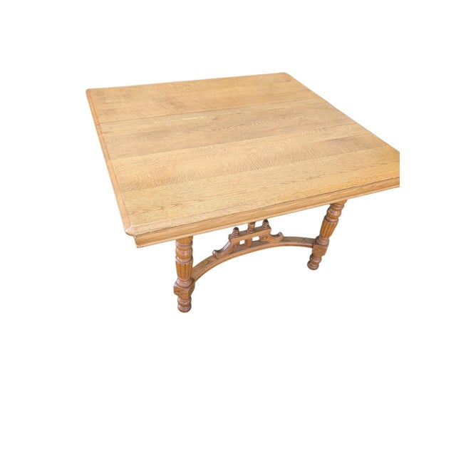 ​An exceptional early 20th-century American extension dining or center library table executed in heavily figured quarter-...