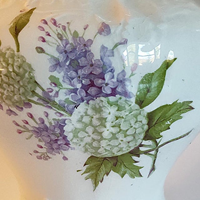 This antique pitcher incorporates beautiful depictions of lilacs on its delicate, elegant form. It has gold detailing a...