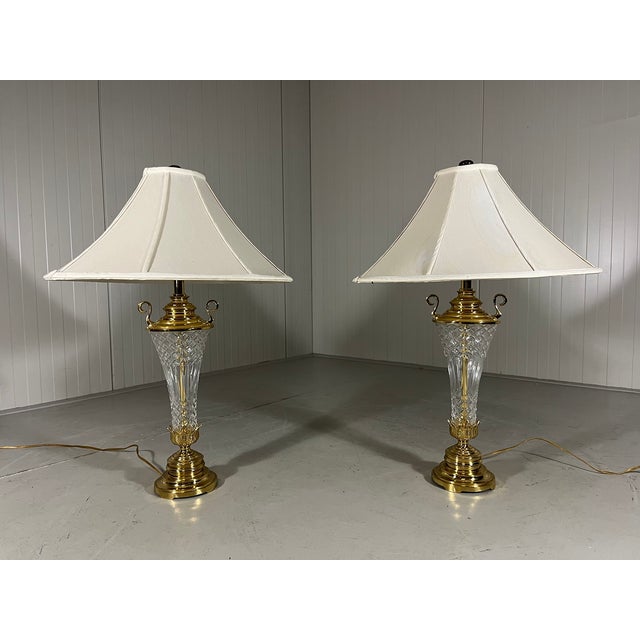 A set of 2 large impressive table lamps. Stand made of brass and etched crystal, original white fabric shades. 1960’s. In...