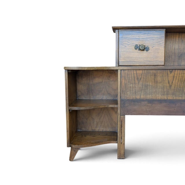 A wide vintage headboard by L.A. Period Furniture, designed as a complete storage wall with two integrated nightstands....