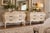 A striking matched pair of generously scaled French Provincial bombé commodes, each measuring an impressive 51 inches...