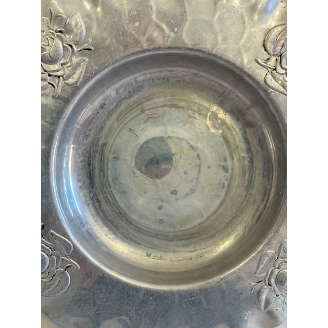 This round hammered aluminum bowl features four hand-chased rose motifs around a wide, ruffled scalloped rim, in the style...