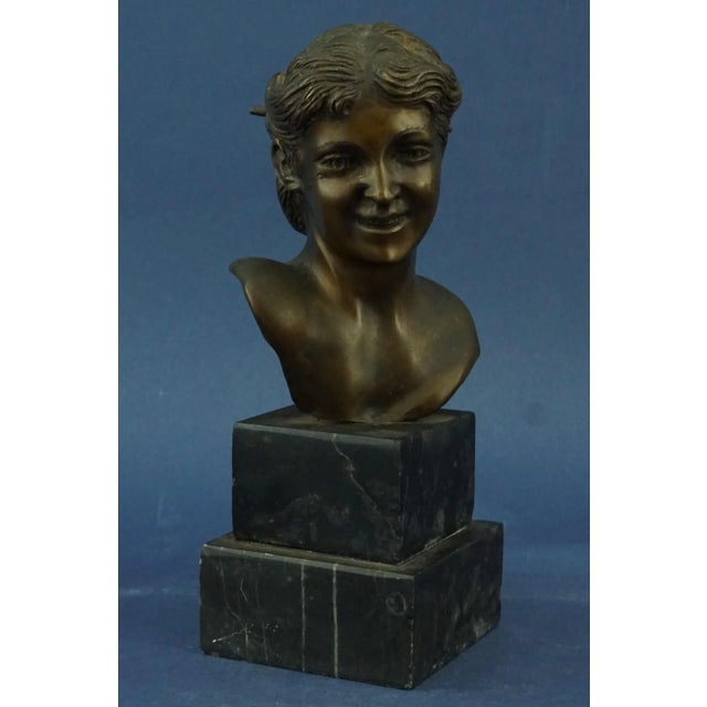A stunning bronze sculpture depicting the bust of a smiling young woman with gathered hair, signed "Fonderia Gemito...