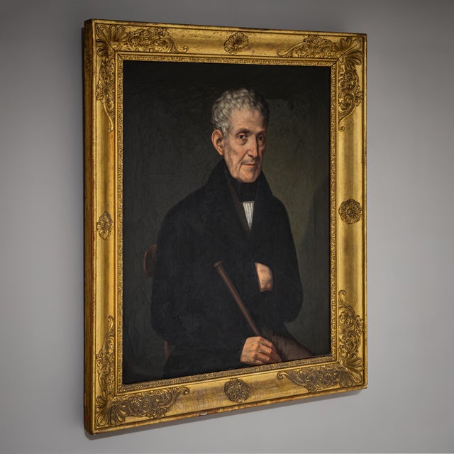 Portrait of an older gentleman from the Biedermeier period, depicted in dark attire, holding a walking stick with one hand...