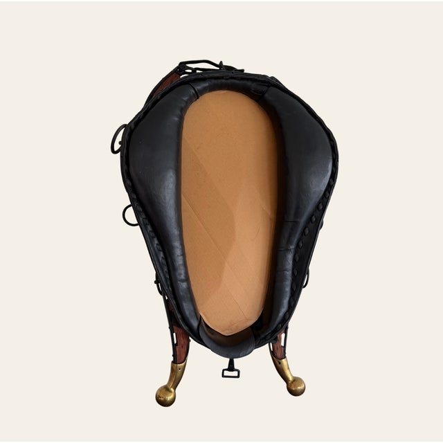A striking vintage equestrian mirror fashioned from a traditional horse collar, combining warm wood, black leather and...