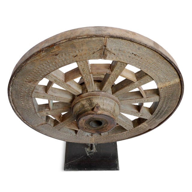 Antique Indian ox cart wheel. Crafted from solid teak hard wood with iron tread and details. Mounted on a solid secure...
