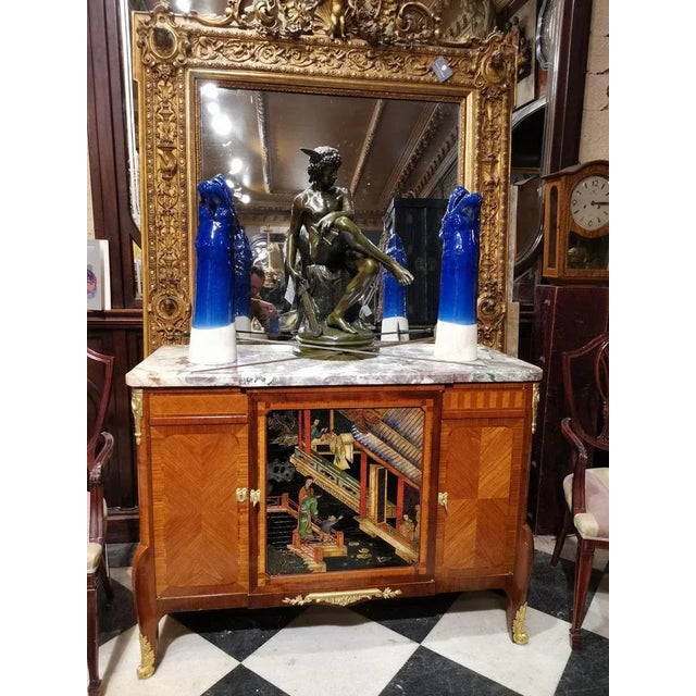 Beautiful Transition style chest of drawers with arched legs. It opens with two Coromandel lacquer doors decorated with...