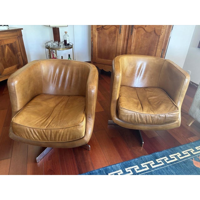 A pair of flamant home interiors swivel armchairs, two distinctive pieces embodying the best of 1970s european design....