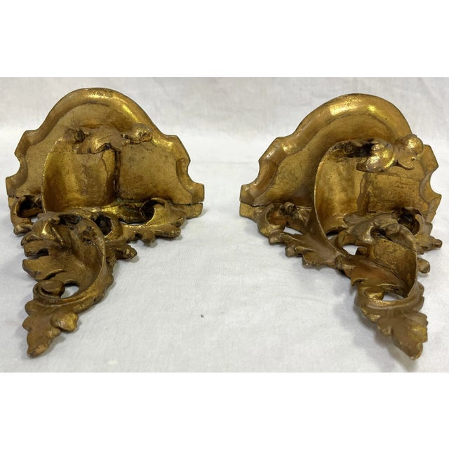 Pretty vintage pair of delicate Italian Rococo style decorative wall brackets. They're made of carved wood and finished in...