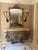 This exquisite gilt‑iron console table features hand‑forged scrollwork, patinated gold leaf accents, and a beautifully...