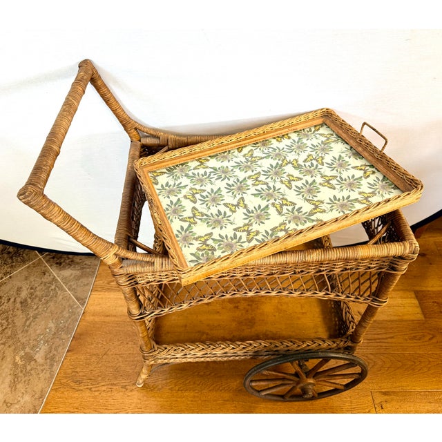 A delightful vintage wicker serving cart showcasing beautifully woven craftsmanship and a timeless silhouette. The cart...