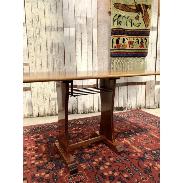 An elegant Danish teak dining table from the 1960s, crafted from warm-stained teak veneer with a simple rectangular top...