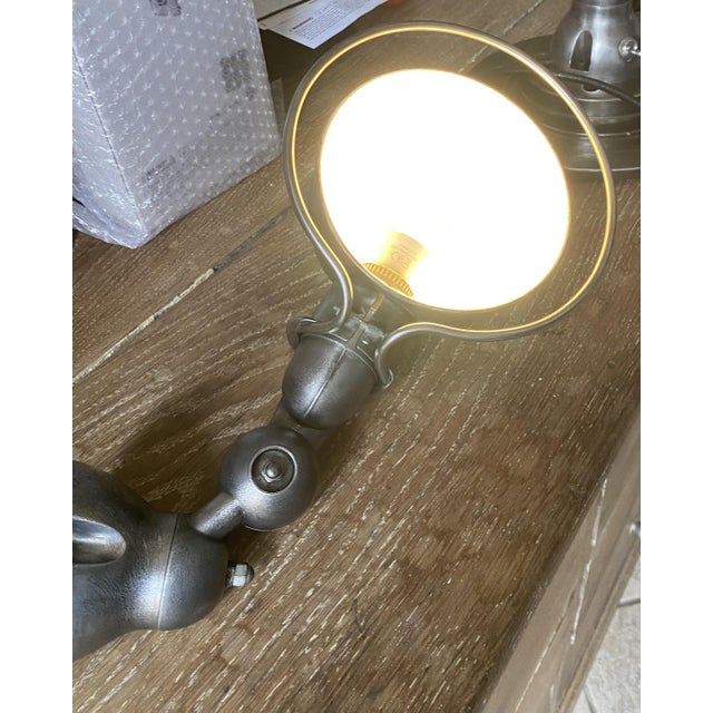 Authentic vintage Jieldé wall lamp. The lamp has been completely stripped, brushed, and finished with a graphite black...